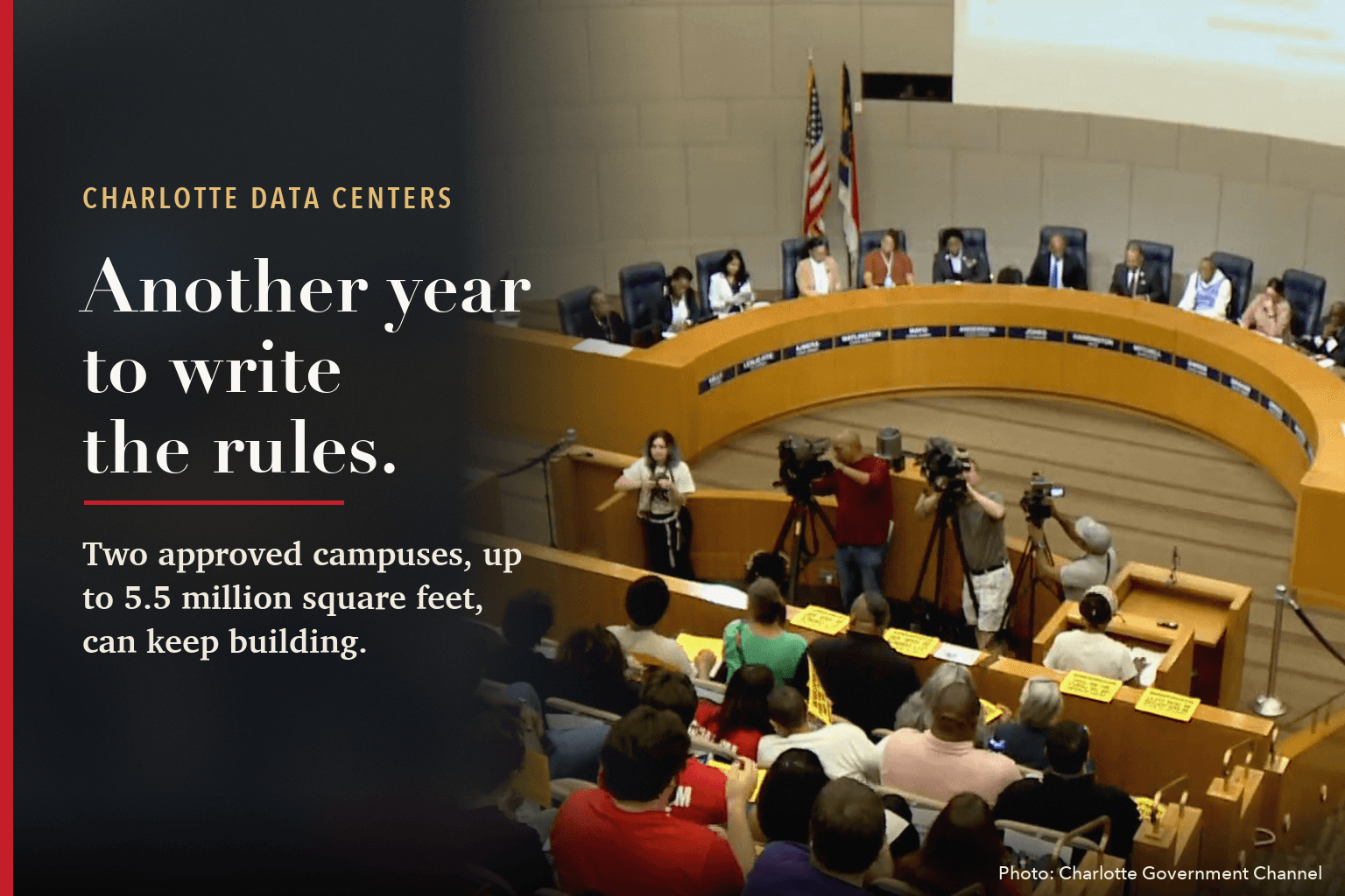 Charlotte City Council chamber during the Oct. 12 data center hearing, the audience holding yellow signs, beside the words: Another year to write the rules. Two approved campuses, up to 5.5 million square feet, can keep building.