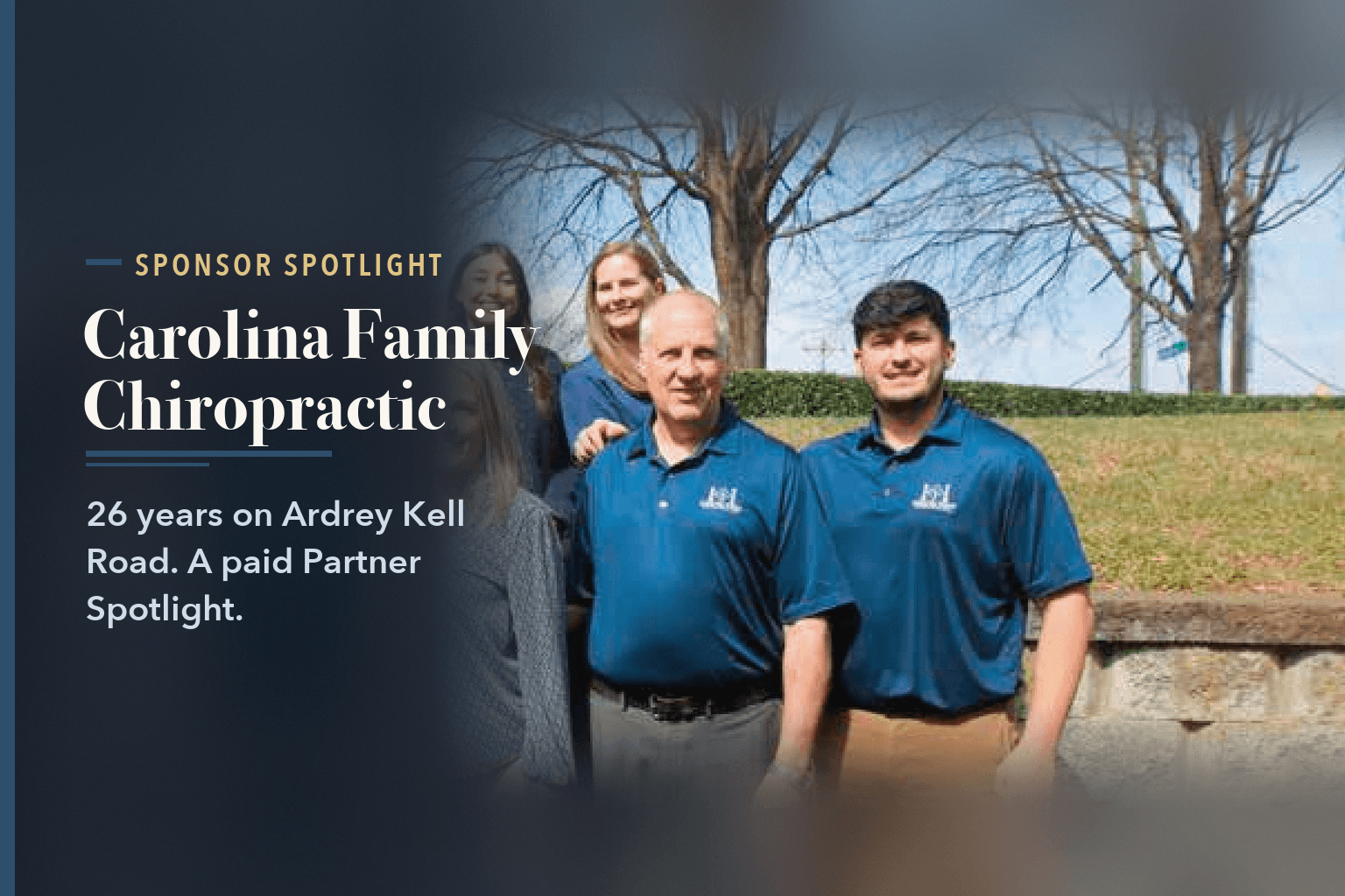 The Carolina Family Chiropractic team of eight in matching navy shirts standing outdoors in front of a stone retaining wall, beside the words Carolina Family Chiropractic: 26 Years of Hands-On Care.