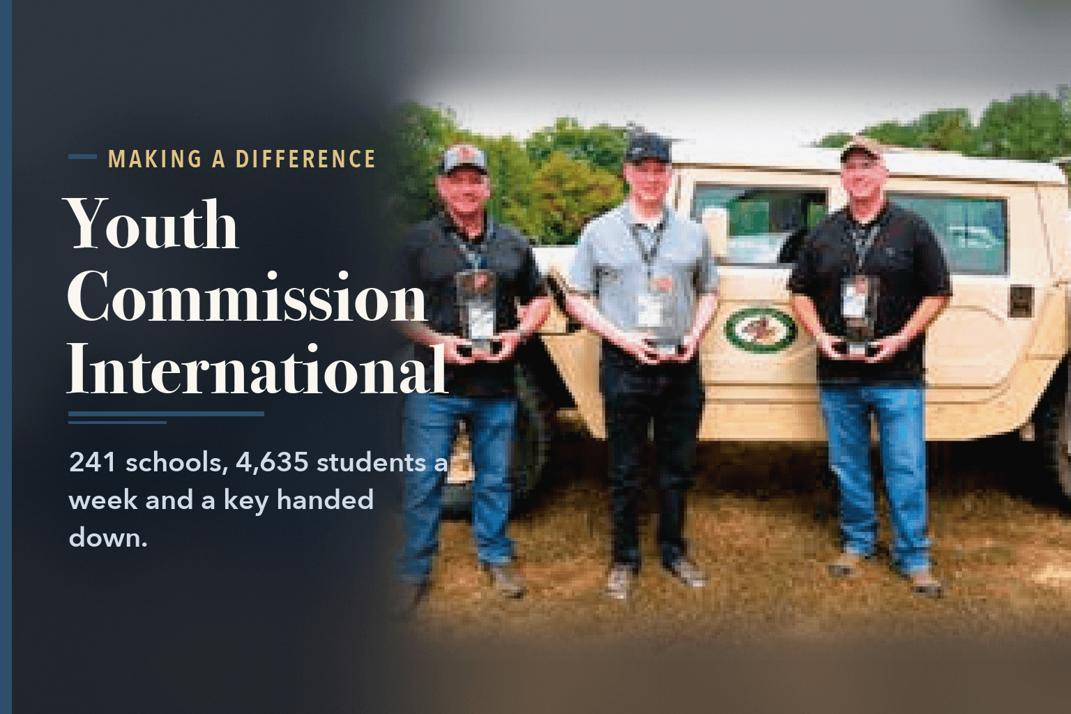 Three men holding awards in front of a tan military-style vehicle on grass, beside the words Youth Commission International, 241 Schools and a Key.
